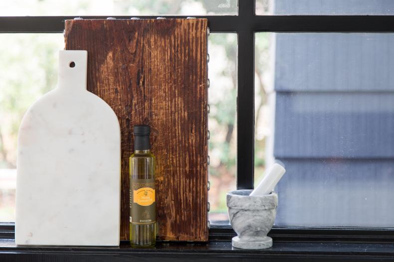 Don’t hide that gorgeous butcher block or marble cutting board away in a cabinet. A windowsill in the kitchen is like having an extra shelf, so put it to good use. 