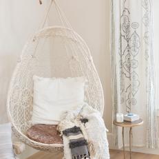 Cozy Hanging Chair With Pom Pom Throw in Teen's Room