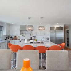 White Open Plan Kitchen With Orange Barstools