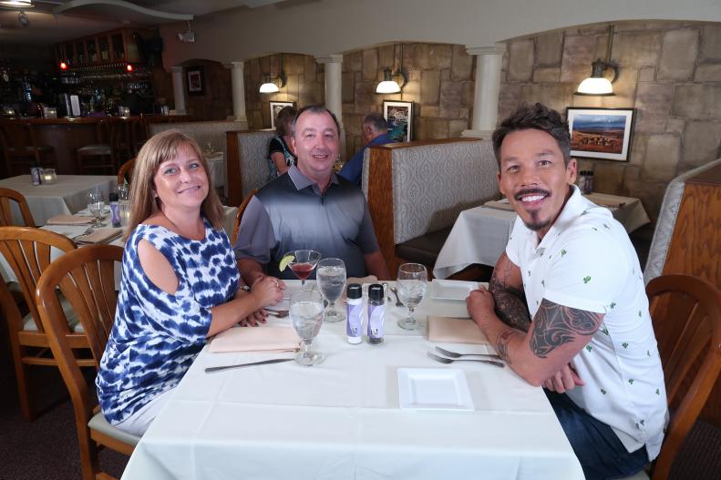 David Bromstad, in a white shirt, poses with our winners during the deliberation shooting