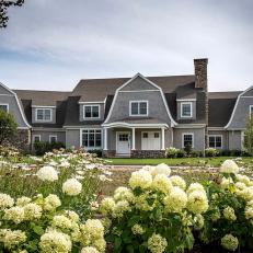 Gray Farmhouse Exterior With White Hydrangeas