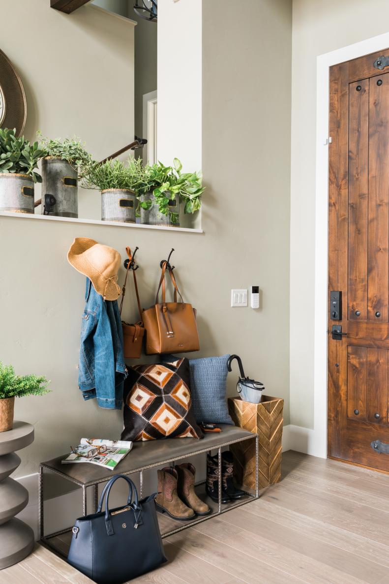 Hooks on the half wall above the bench keep handbags, hats and jackets organized and within reach, while a tall woven basket offers the perfect storage container for umbrellas. 