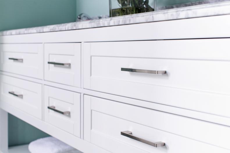 Long and sleek brushed nickel pulls on the vanity drawers coordinate with the clean lines of this modern bathroom that offers both function and style. 