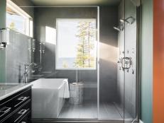 Light fills every inch of the spacious master bathroom at HGTV Dream Home 2019. Using a glass wall between the walk-in shower and bath area allows natural light to keep the room feeling bright and airy.