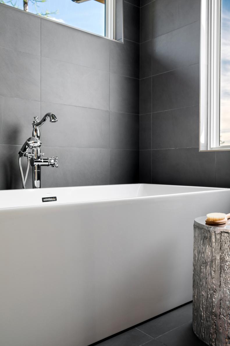 The clean lines of the bathtub match the modern feel of the gray tile used in the walk-in master bath and shower.
