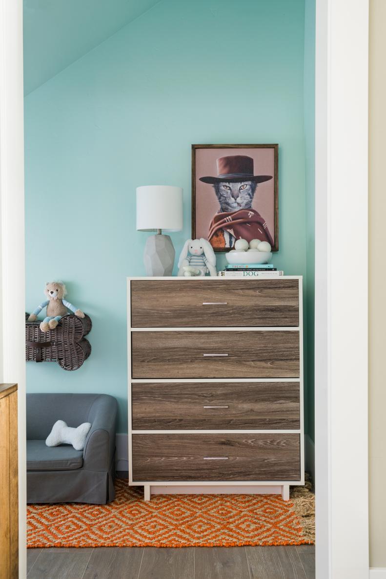 A tallboy dresser with clean modern lines and four spacious drawers provides a spot for storing everything from favorite pet toys and to cat and dog sweaters, helping keep the nook free from clutter. 