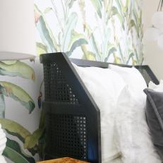 Black Cane Bed and Leafy Wallpaper