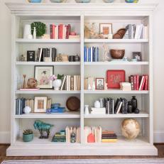 Colorful Bookcase Topped With Globes Adds Personal Touch to Family Room