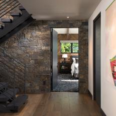 Modern Entryway With Dark Wood Stairs, Stone Accent Wall