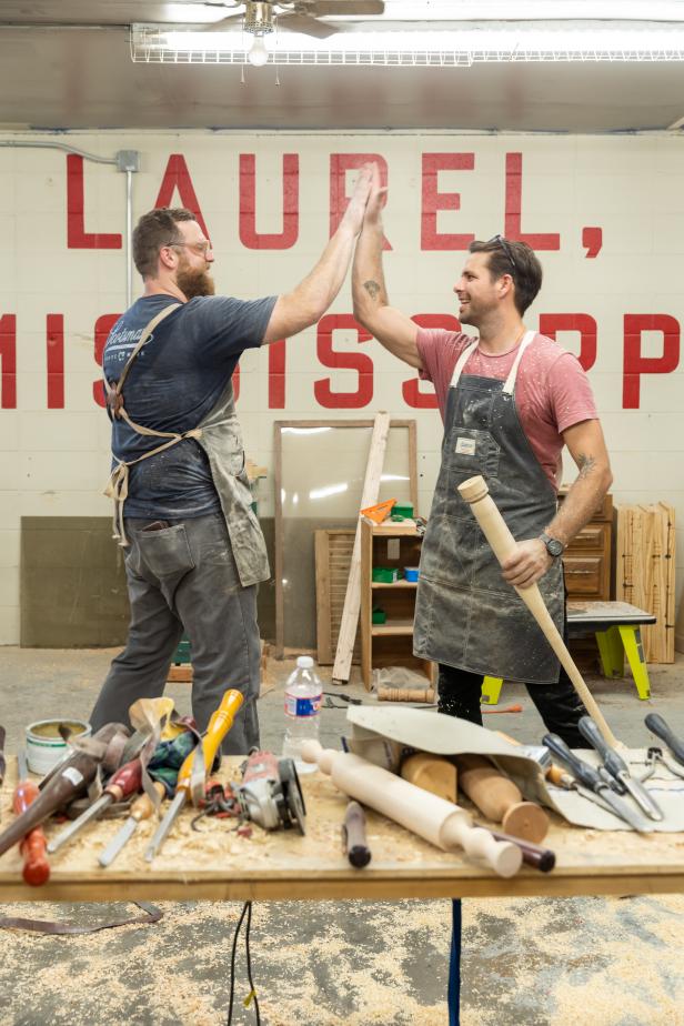 Ben Napier (L) and Jason Pickens (R) work together on building baseball bats at the Scotsman Workshop in Laurel, Mississippi.  They celebrate with a high five as both of them finished before the hour time limit was up. (action)