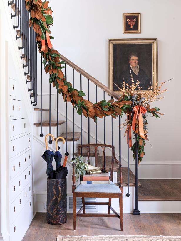 Designer Gordon Dunning uses thistle and winterberry as punctuation on this gorgeous bunting of magnolia leaves ornamenting a staircase at the Atlanta Homes & Lifestyles 2018 Home for the Holidays Showhouse and Marketplace.