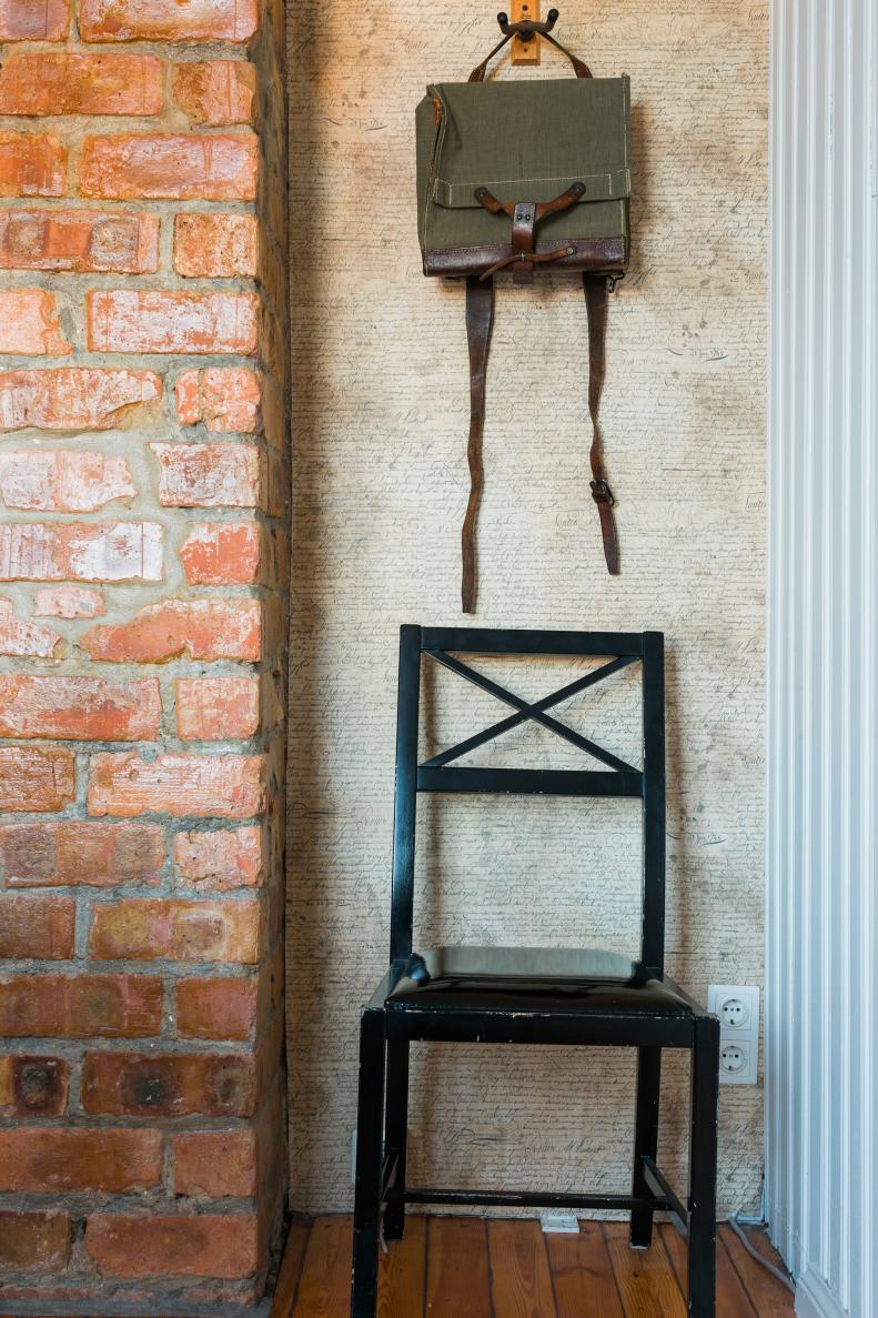 Messenger Bag Hanging on Wall Above Dining Chair