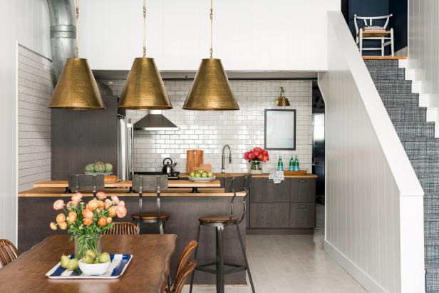 A loft kitchen that features cabinetry and butcher block countertops. 