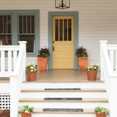 Neutral Craftsman Porch with a Yellow Front Door