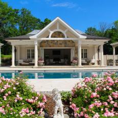 Pool House Flanked By White Pergolas 