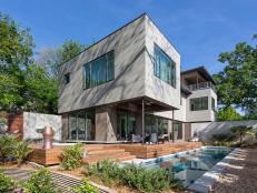 Cara and Jose design their home to be stylish and energy efficient. This is a view from the rear garden looking up at the house. The house is clad in a concrete panel on the second floor, and the lower level is European stucco. The home is surrounded by water, which you can see and hear with the fountains. When the sun and pool lounging is too much for guests, the couple designed a Lanai, or veranda,  not far from the pool. The Lanai provides the perfect amount of shade and captures the breeze that crosses the property.
