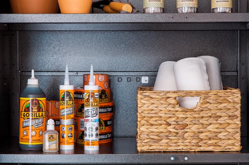 The garage includes a handy supply of glue, construction adhesive, sealant and more for various home projects and rolls of paper towels stored in an attractive woven basket. 