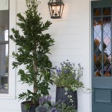 White Farmhouse Porch with Potted Plants 
