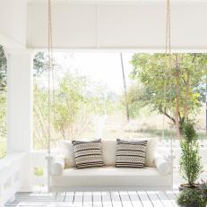 White Farmhouse Front Porch with White Porch Swing