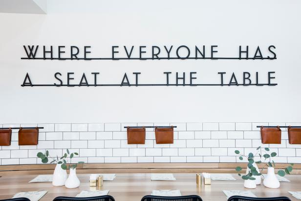 Magnolia Table restaurant interior: WHERE EVERYONE HAS A SEAT AT THE TABLE sign, white subway tile, and black and white interior. #magnoliatable #restaurant #Waco #fixerupper