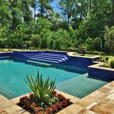 Blue and Turquoise Swimming Pool With Corner Garden