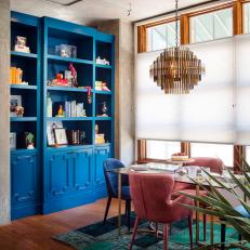 Eclectic Loft Dining Room With Blue Bookshelf