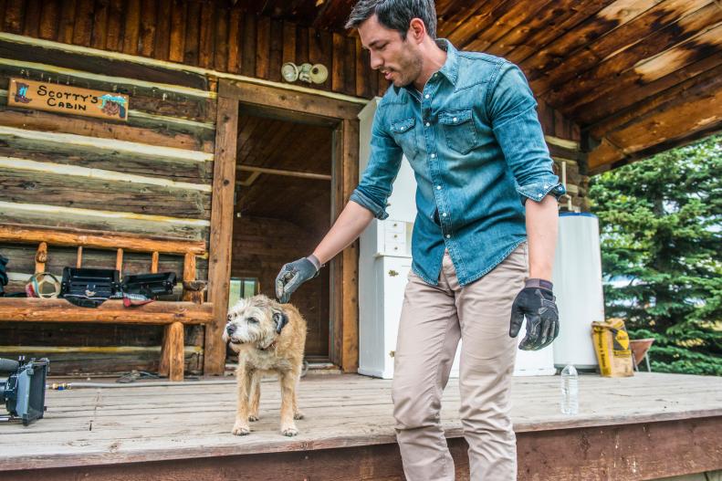 Drew Scott playing with the Bew's farm dog on their ranch in the foothills of the Rockies, as seen on Property Brothers at Home on the Ranch.