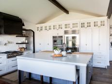 Vaulted Ceilings Accent a Bright Kitchen That Features a Large Island and White Cabinetry