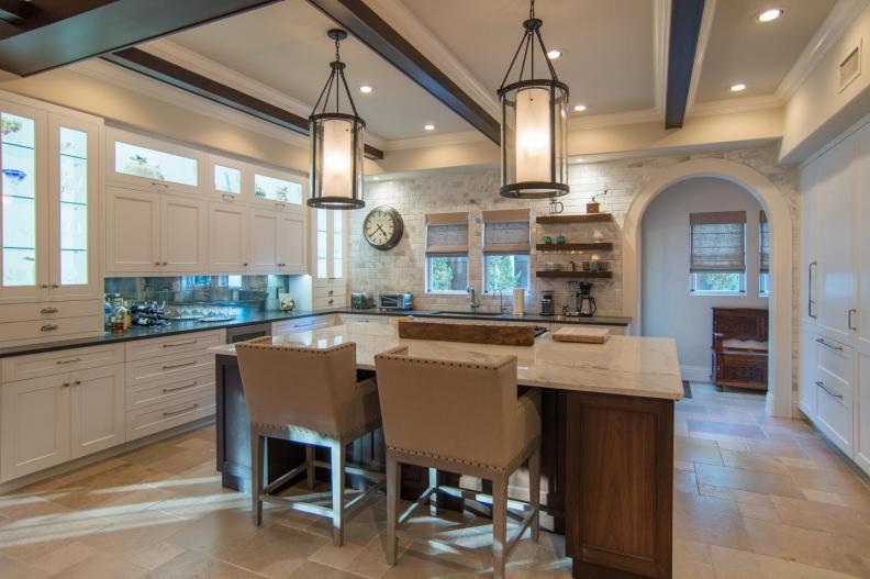 A traditional white kitchen with open shelves and wood beams. 