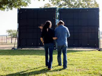 Chip and Joanna Gaines walk out to pull the Brooks' canvas, as seen on Fixer Upper. (behind-the-scenes)