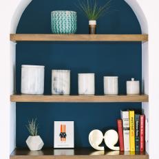Arch Bookshelf With Navy Interior, Wood Shelves and Contemporary Decor
