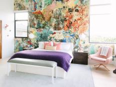 Modern Master Bedroom With Abstract Accent Wall And Pastel Pillows And Accent Chair