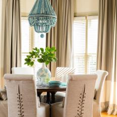 Contemporary Dining Nook With Upholstered Dining Chairs And Blue Beaded Chandelier