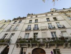 A Paris apartment building that features a cream stone exterior. 