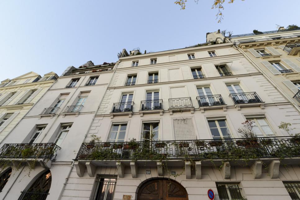 A Paris apartment building that features a cream stone exterior. 