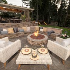 Contemporary Outdoor Fire Pit Sitting Area With Stone Wall Seating And Neutral Chairs
