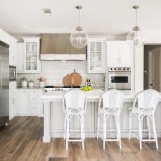 Contemporary White Kitchen With Island Seating And Modern Pendants And Appliances