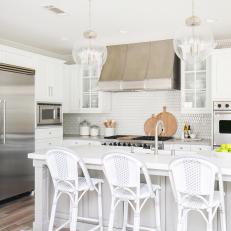 Contemporary Kitchen With White Cabinets And Backsplash And Modern Pendant Lights