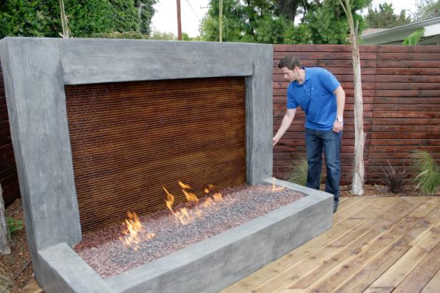 Host Tarek El Moussa tries out the fire element on the water feature in Long Beach, CA as seen on HGTV's Flip or Flop. (Action)