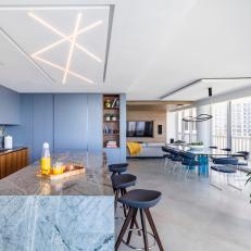 Modern Condo Open Concept Kitchen And Dining Room With Blue Cabinets and Marble Island
