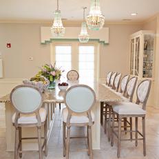 Traditional Eat In Kitchen With Marble Counter Seating And Chandeliers