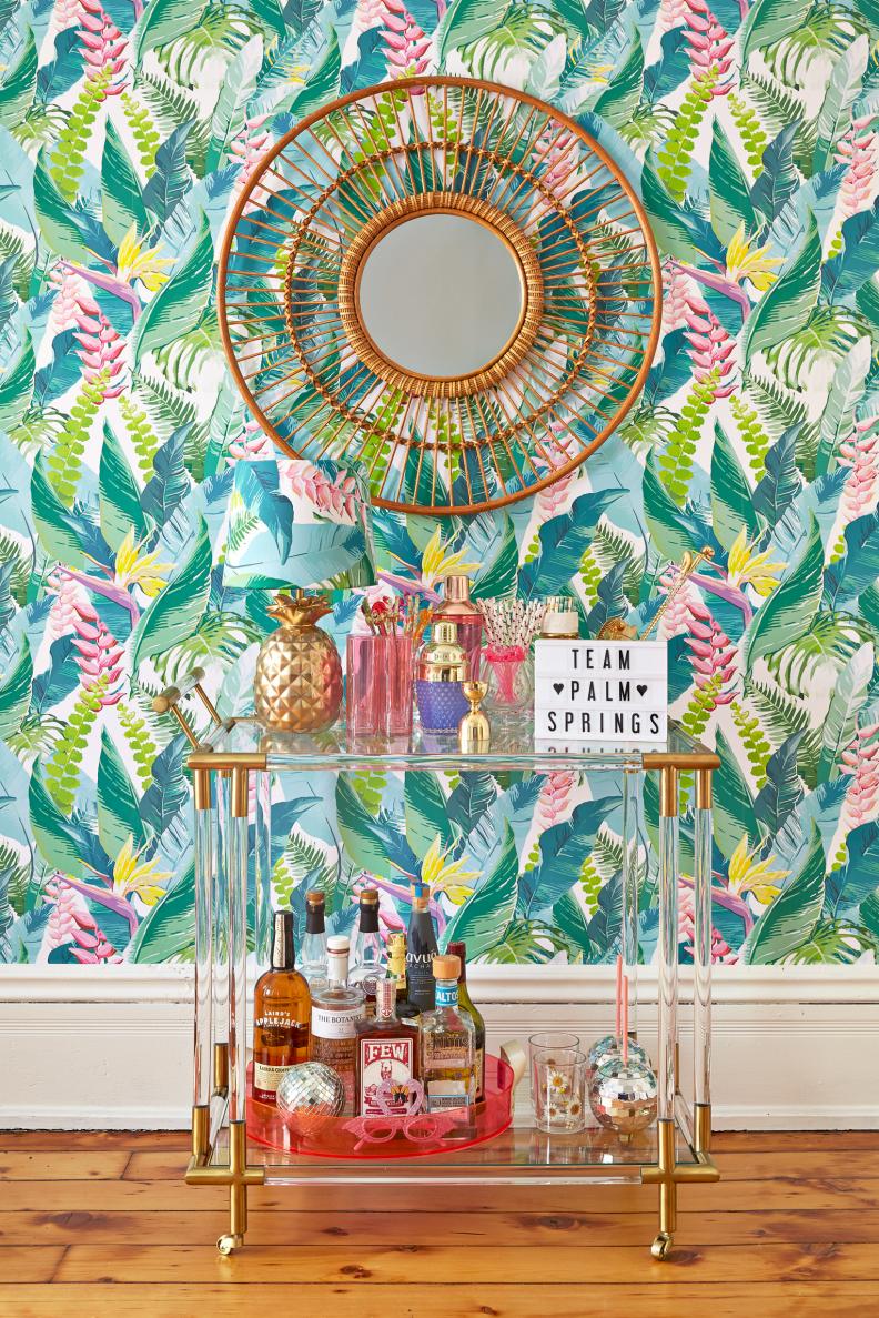 eclectic living room with floral wallpaper and lucite bar cart