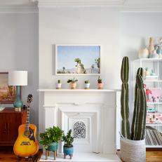 White-Painted Fireplace Decorated With Colorful Planters