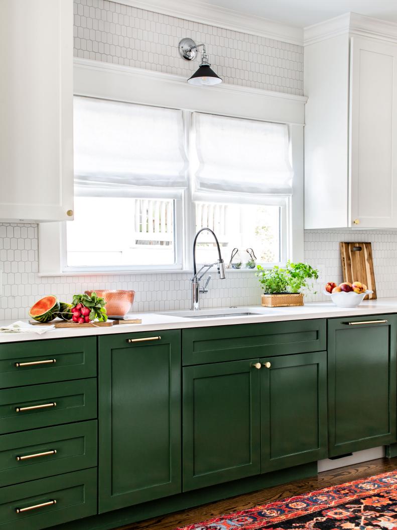 transitional galley kitchen with green cabinets and gold hardware
