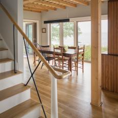 Cottage Dining Room With Natural Wood Table And Chairs And Exposed Rafters
