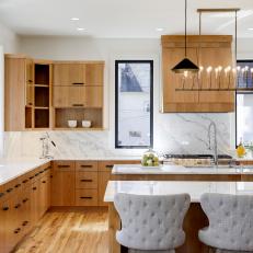 Cool Marble Surfaces Meet Warm Wood Cabinets in Kitchen