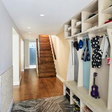 Mudroom Entryway With Color-Coded Cubbies and Wooden Stairs