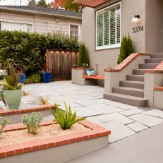 Front Yard With White Stone Surface and Red Brick Accents