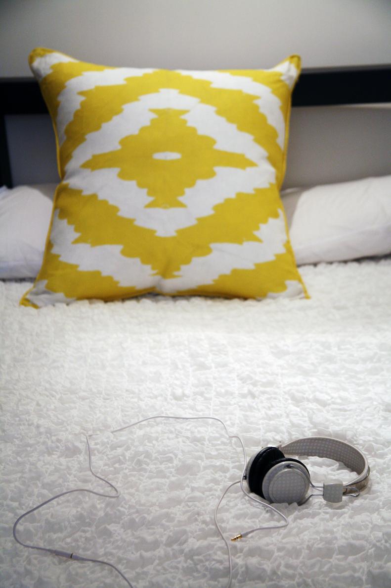 Yellow is a strong color, and part of what can make it a challenge to work with in the home is how easily it can overwhelm the other colors in a space. One simple solution is to break up the color yellow by using it in a patterned piece. On this bed, the simple infusion of white in the bright, citron yellow of this pillow creates a beautiful pattern that fits perfectly into this minimalist bedscape. The Haze pillow (https://www.aphrochic.com/product/haze-2/) is a modern take on ikat in today’s latest color.  