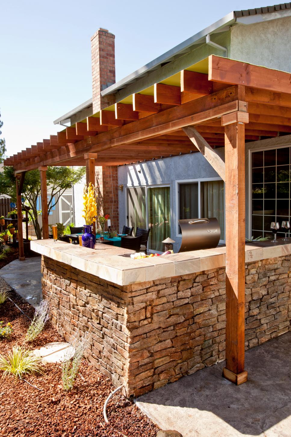 rustic flagstone outdoor kitchen with granite-tiled bar | hgtv
